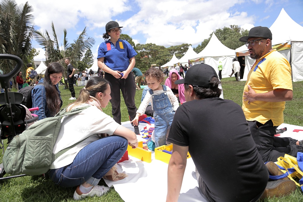 Una niña juega con crayolas en medio de un grupo de adultos