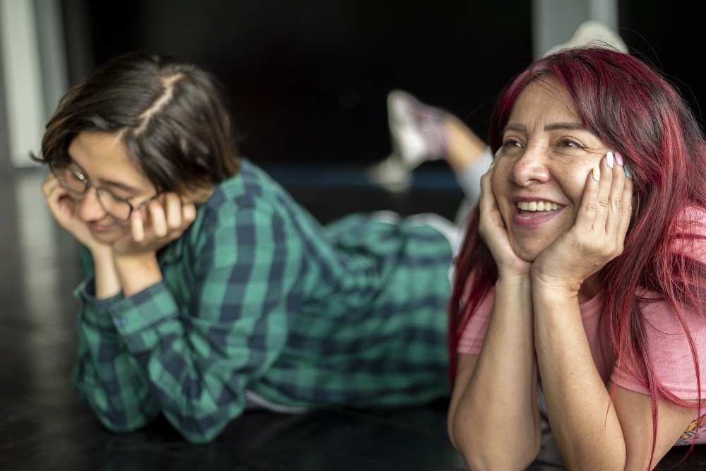 Dos personas recostadas en el suelo sonriendo